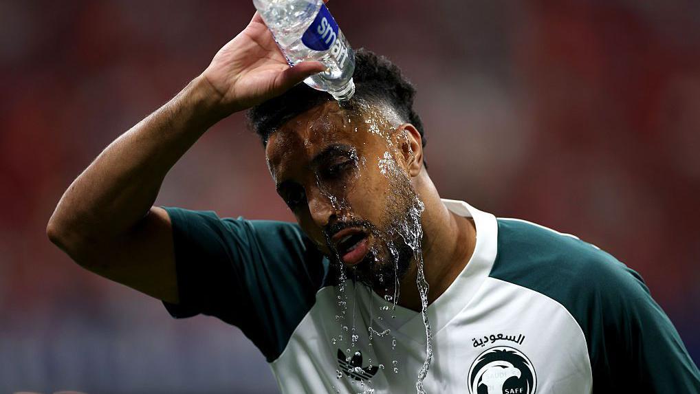 سالم الدوسري، لاعب المنتخب السعودي رقم 10، يسكب الماء على نفسه خلال الإحماء قبل مباراة إسبانيا والسعودية ضمن منافسات المجموعة الثامنة في كأس العالم 2026